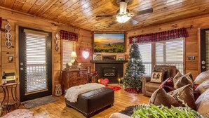 Interior acogedor de una cabaña con chimenea, un árbol de Navidad y un espacio de descanso cómodo.