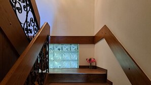A wooden staircase with a glass panel and a vase of flowers. - Wonderful private villa for 9 guests with TV, balcony, pets allowed and panoramic view (Wald Im Pinzgau)
