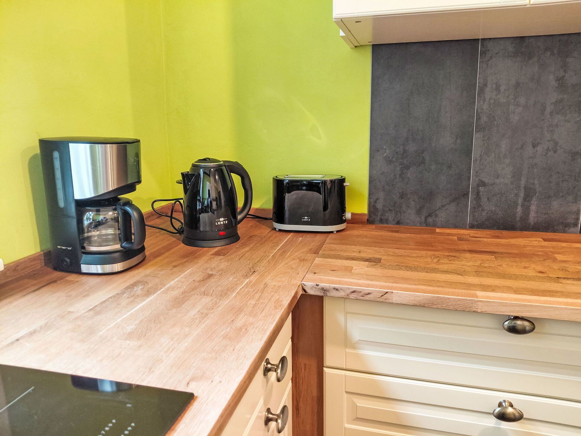 Eine Küche mit Kaffeemaschine, Wasserkocher und Toaster auf der Arbeitsfläche.