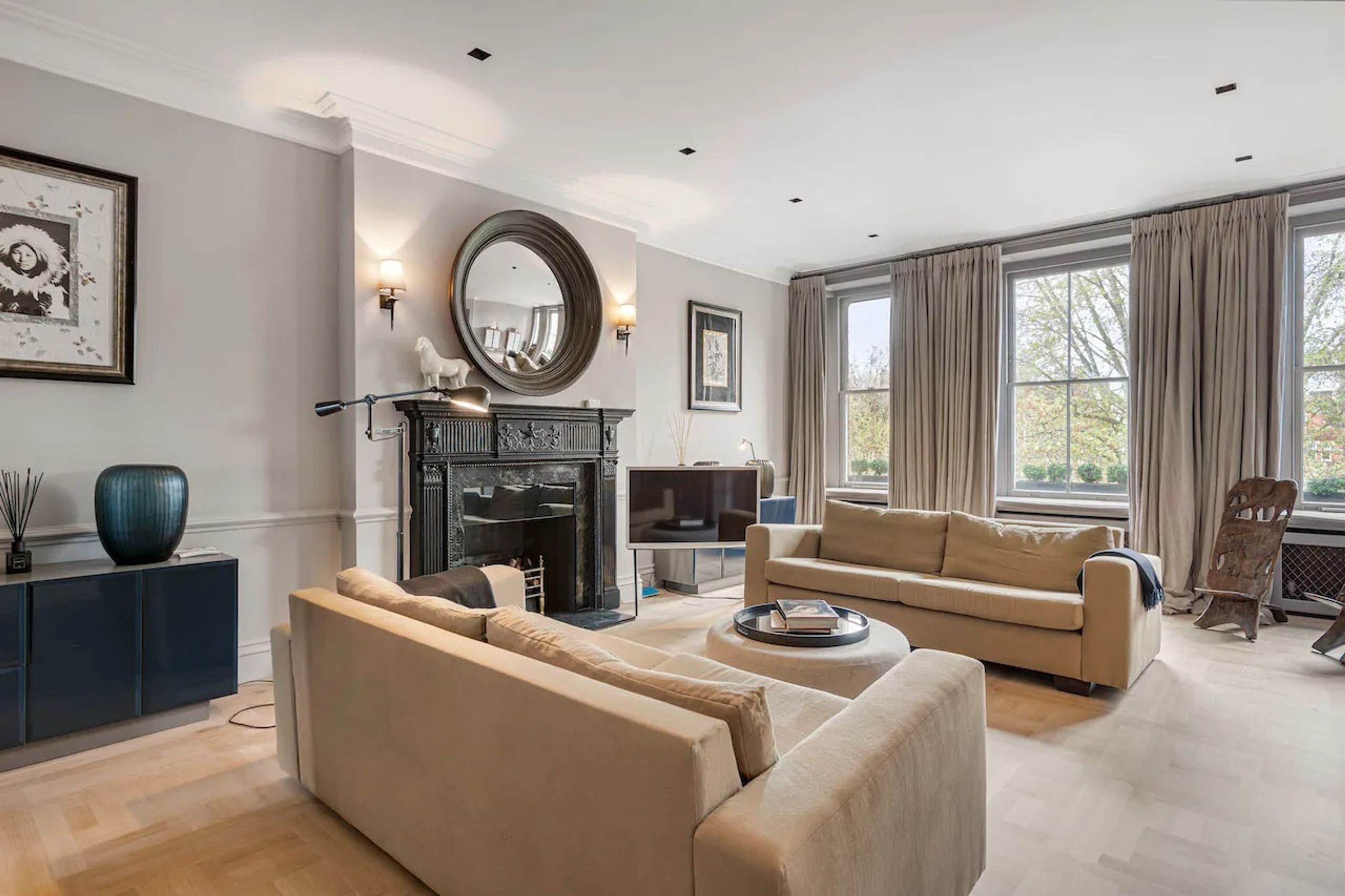 A modern living room with a fireplace, a large mirror, and a sofa.