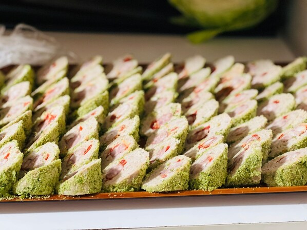 Une plaque de pâtisseries coupées en tranches, avec une couche extérieure verte et une garniture blanche, disposées en rangées.