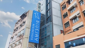 Ein modernes Gebäude mit einem auffälligen, blauen Schild für Buejay Residences.