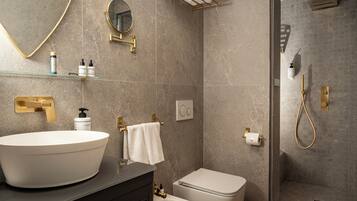 A modern bathroom with a large vessel sink, a toilet, a shower area, and a mirror.