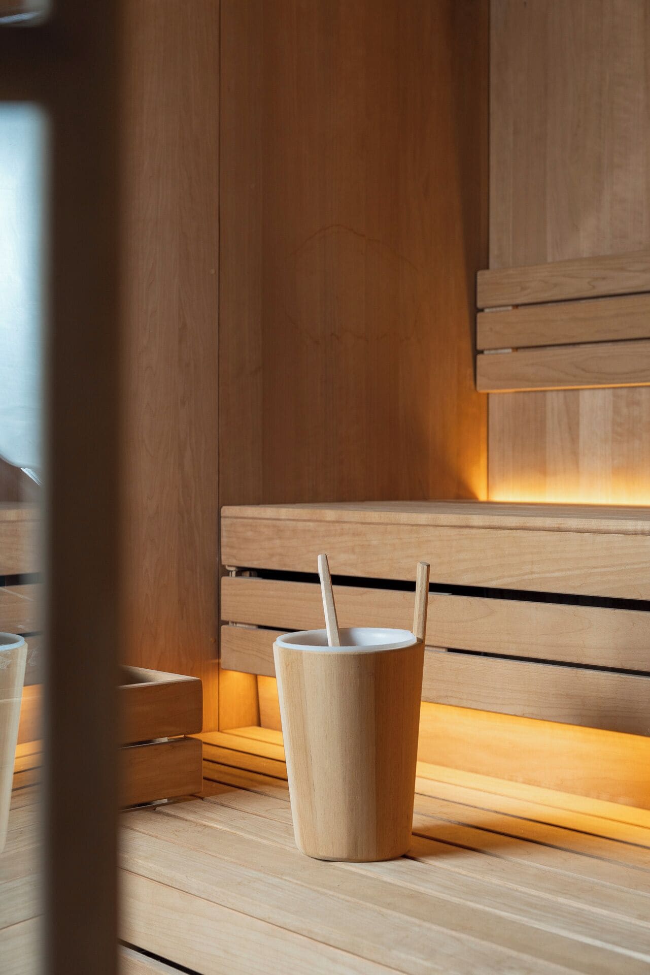 A wooden bench with a cup and a spoon, indicating a seating area with amenities.