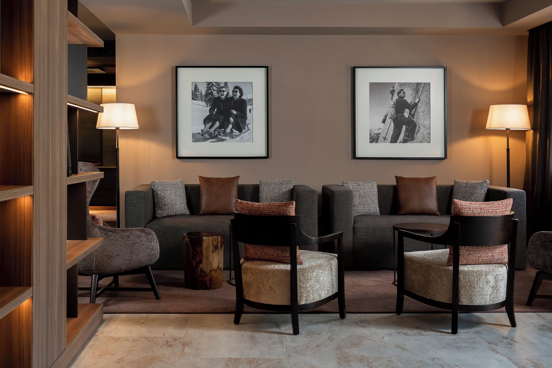 A modern living room with a sofa set, two armchairs, a coffee table, and two framed black and white photographs on the wall.