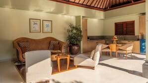 A spacious living area with a high ceiling, a sofa, a dining table, and a kitchen in the background. - Villa Elegant by Exotiq (Seminyak)