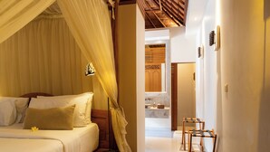 A bedroom with a bed, a bedside table, a nightstand, and a bedside lamp. - Villa Elegant by Exotiq (Seminyak)