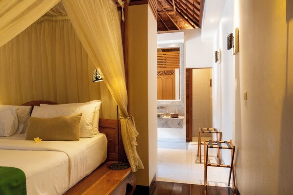 A bedroom with a bed, a bedside table, a nightstand, and a bedside lamp. - Villa Elegant by Exotiq (Seminyak)