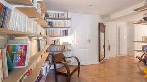 Una stanza con scaffali, una sedia di legno e una porta bianca.