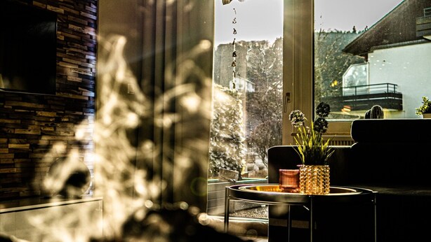 A modern living room with a fireplace, a sofa, and a view of a mountain landscape through large windows. - Apartment 'Mellies' with Private Terrace, Garden and Wi-Fi (Willingen (Upland))