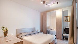 Ein modernes Hotelzimmer mit Bett, Nachttisch und Spiegel.