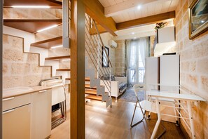 A modern kitchen with wooden flooring, a white countertop, and a built-in oven.