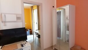 Une chambre d’hôtel équipée d’une télévision, d’un bureau et d’une armoire.
