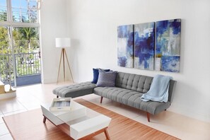 A modern living room with a sectional sofa, a white coffee table, and abstract art on the wall.