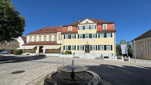 A public square with a fountain in the center, surrounded by buildings with traditional architecture. - TOP VCH Landschloss Korntal (Korntal-Munchigan)