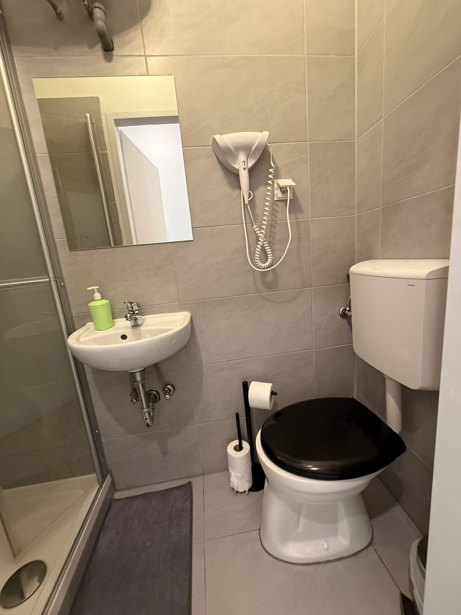 A bathroom with a toilet, sink, and shower.
