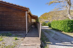 Un bâtiment en bois doté d’un porche couvert et d’un chemin de gravier menant à l’entrée.