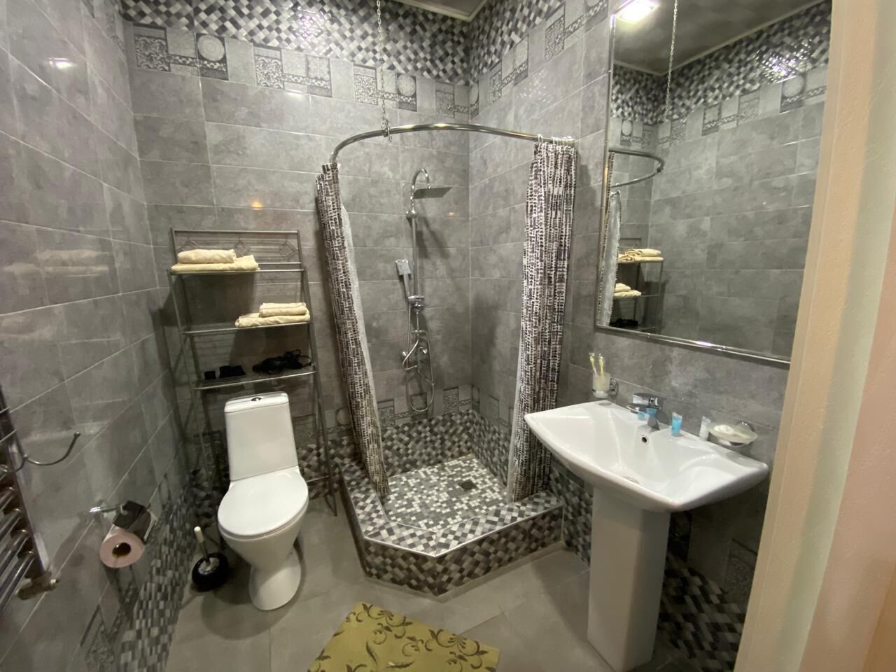 A bathroom with a shower, toilet, and sink.