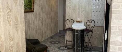 A cozy living area with a patterned floor, a sofa, and a dining table with chairs.