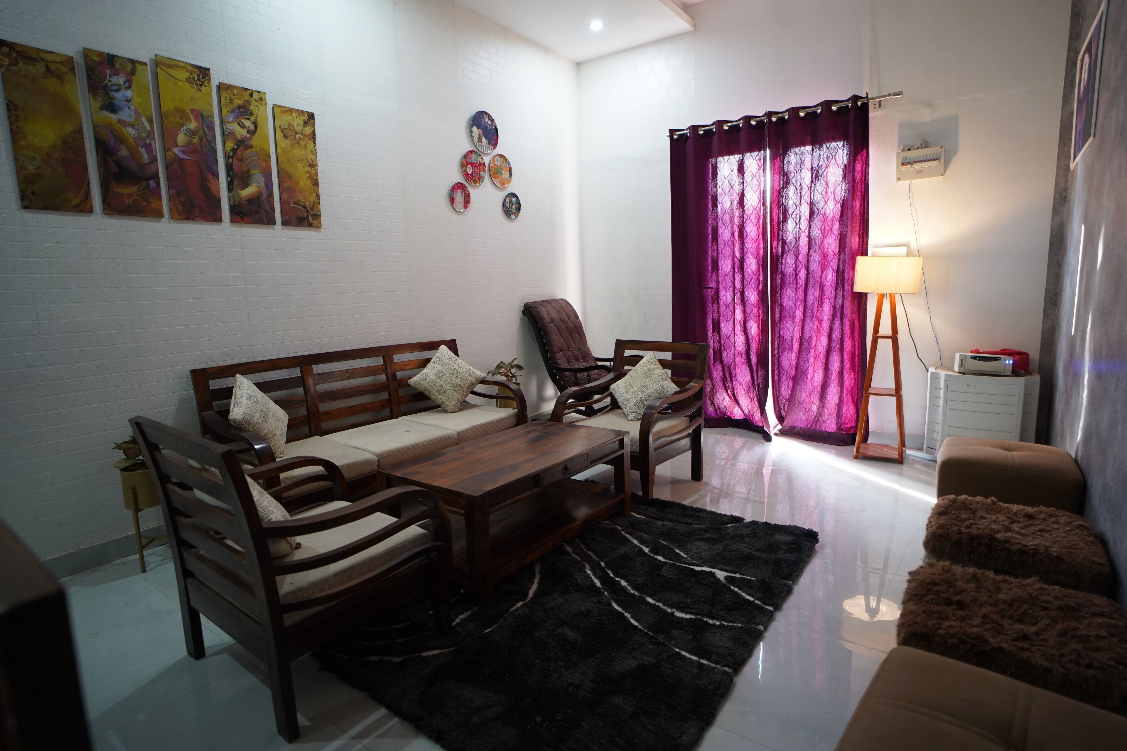 A living room with a sofa set, a coffee table, a rug, and a lamp.