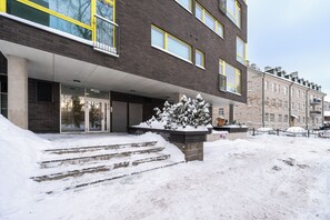 A modern building with a brick facade, large windows, and a snow-covered entrance. - 2BR/Parking Included/Wi-Fi/next to Old Town (Tallinn)