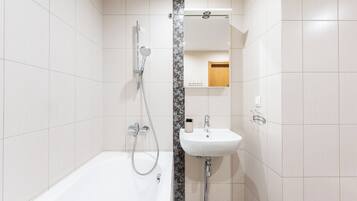 Ein modernes Badezimmer mit Badewanne, Dusche und Waschbecken.