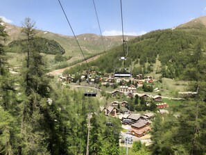 Ein Bergresort mit Seilbahnen, Holzhäusern und Blick auf ein Tal.