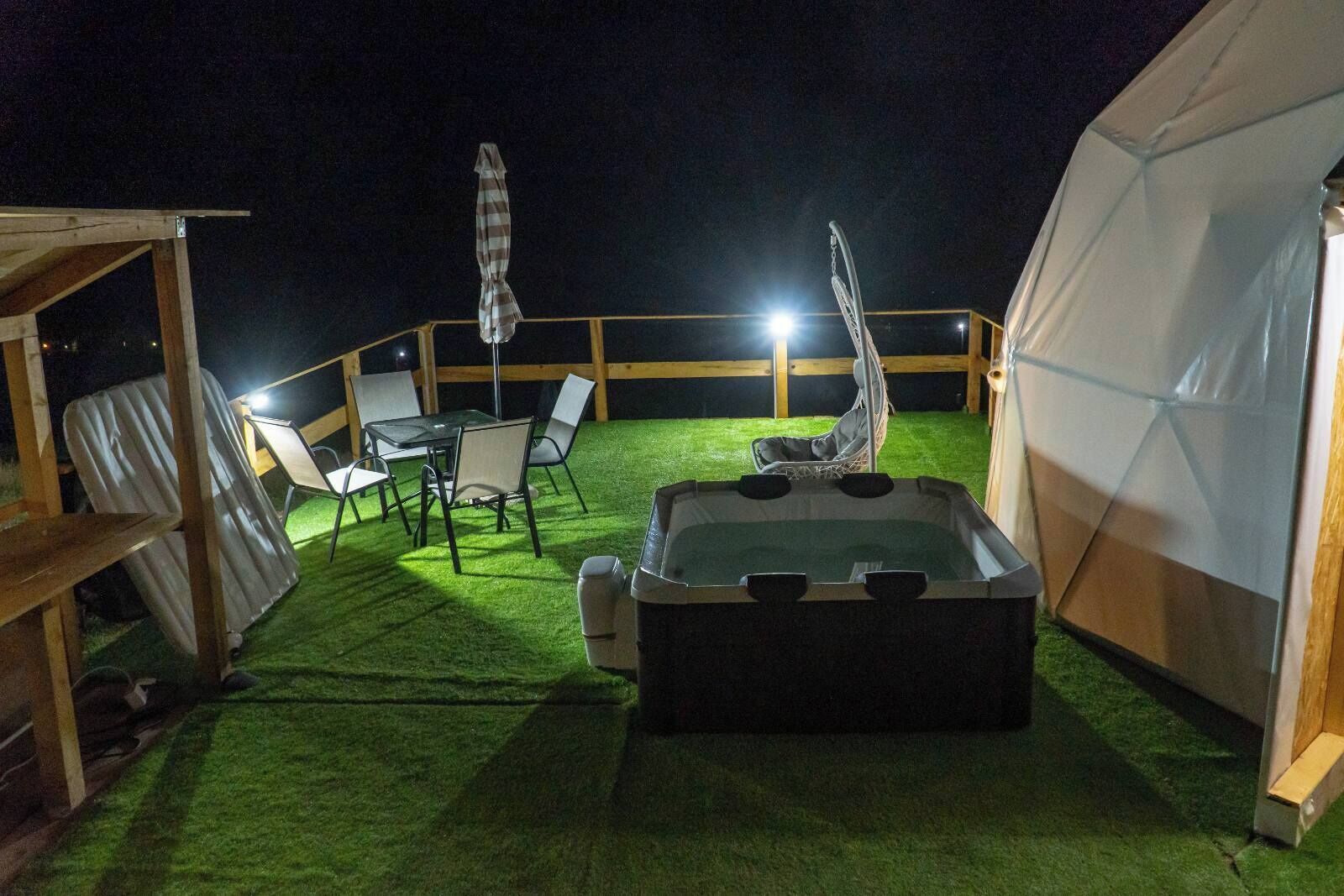 Une terrasse sur le toit dotée d’un jacuzzi, d’un espace salon extérieur et d’une structure en forme de tente.