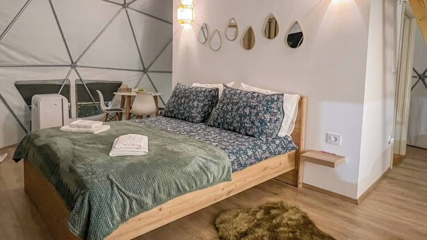 A cozy tent-style bedroom with a bed, pillows, a small table, and a chair. - Cozy glamping  in heart of National park Durmitor with private HOT TUBE (Žabljak)