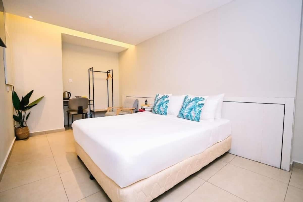 Una camera d'albergo moderna con un letto grande, una scrivania e una sedia.