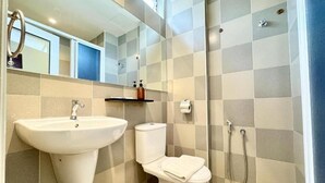 Une salle de bain avec un lavabo, des toilettes et une douche.