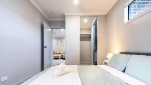 Quarto de hotel com cama, mesa de cabeceira e janela.