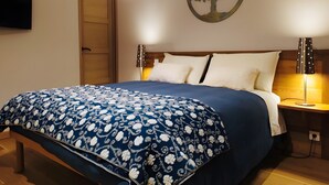 Un dormitorio con una cama, un adorno de árbol en la pared, un televisor y dos lámparas de noche.