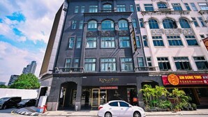 Een hotel met een moderne gevel, een duidelijke ingang en een restaurant genaamd "XIN DONG TING" op de begane grond.