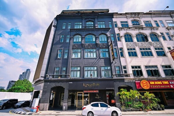 Een hotel met een moderne gevel, een duidelijke ingang en een restaurant genaamd "XIN DONG TING" op de begane grond.