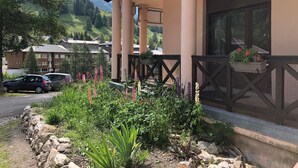 Un hotel con un espacio exterior cubierto, paredes de piedra y una variedad de plantas.