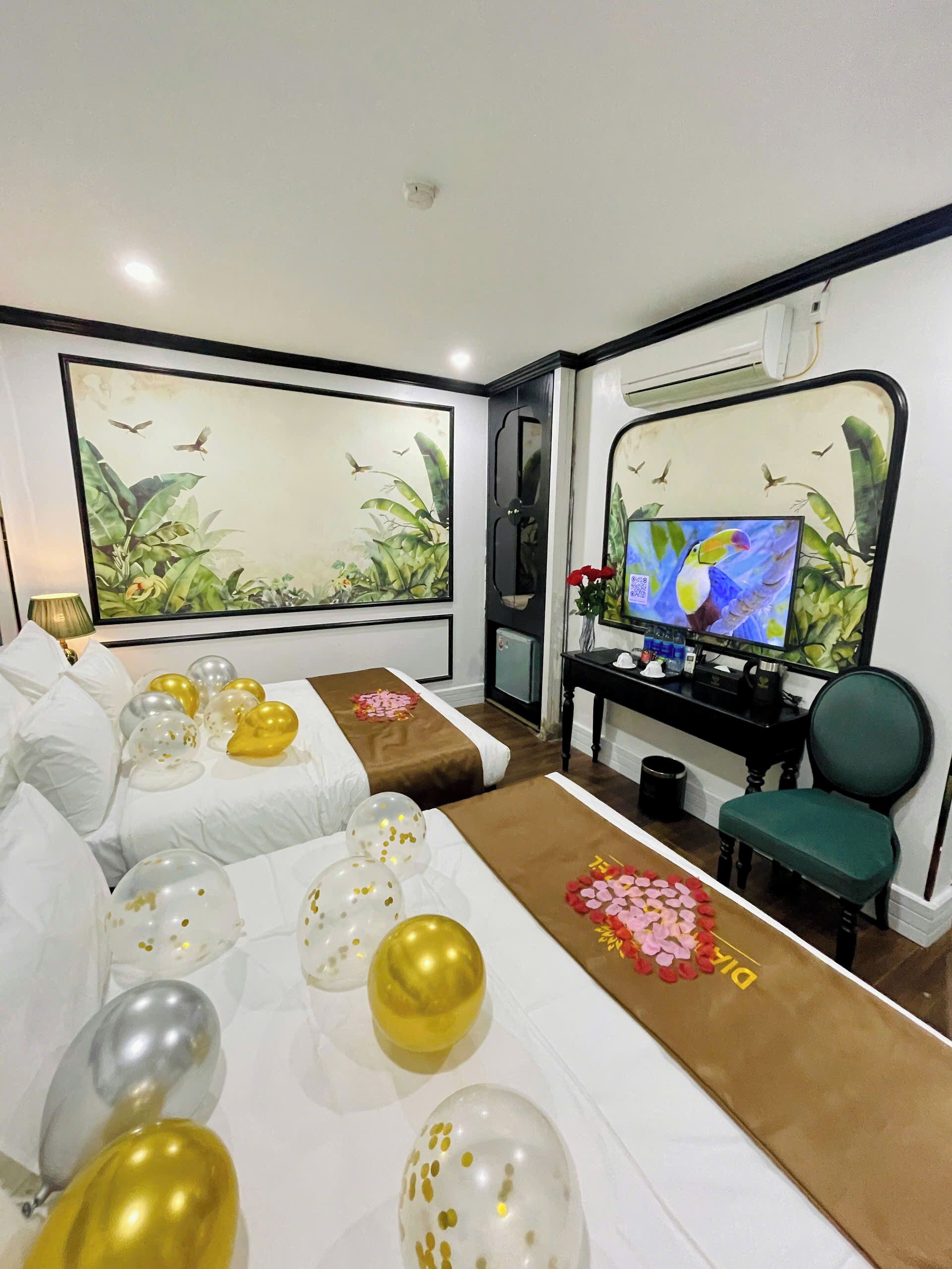 Ein Hotelzimmer mit einem Bett, einem Schreibtisch mit Computer, einem Stuhl und einem Fernseher.