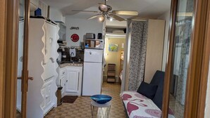 A compact living space with a kitchenette, a dining area, and a bedroom. - Ground-floor Studio Cabin with terrace. Pets welcome! (leucate)