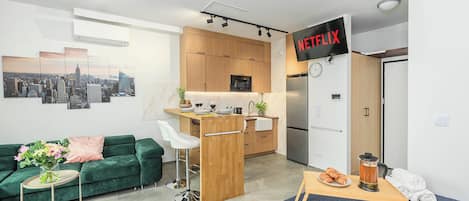 Un apartamento moderno con kitchenette, comedor y sala de estar.