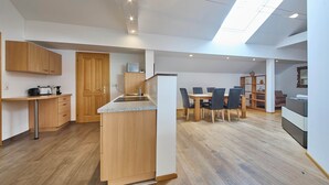 Een moderne keuken met houten kastjes, een inbouw eiland en een dakraam.