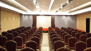 A conference room with rows of chairs, a stage, and a modern ceiling design. - Hotel Beach Park (Cox's Bazar)