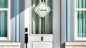 Eine weiße Haustür mit Fenster und einem Schild, auf dem 'Colorado Vacation' steht.