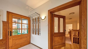 A wooden door with a glass panel, a coat rack, and a light fixture on the wall. - Ferienwohnung Salzafeld (Bad Mitterndorf)