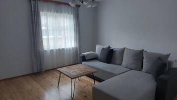 Condo tiện nghi đơn giản, 1 phòng ngủ, được phép mang theo vật nuôi, quang cảnh vườn | Khu phòng khách | TV màn hình phẳng 50-inch có truyền hình cáp