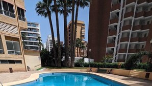 A swimming pool surrounded by palm trees and high-rise buildings. - Apartment,Rincon de Loix, Benidorm, sea views, s.pool, pk, air conditioning,wifi (Benidorm)