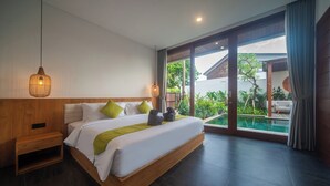 Una habitación de hotel moderna con una cama grande, una mesita de noche de madera, una lámpara colgante y vistas a una piscina a través de puertas correderas amplias.