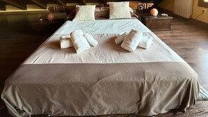 A spacious attic bedroom with a large bed, wooden beams, and a cozy atmosphere. - LOS RELOJES HOUSE (La Adrada)