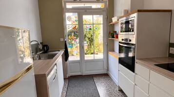 Eine kleine Küche mit Kühlschrank, Backofen und Spüle.