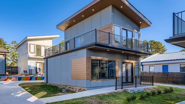A modern two-story house with a balcony, large windows, and a well-maintained lawn. - Tiny Home Atlanta Retreat (Union City)