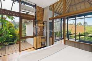 A modern interior with large windows, a wooden floor, and a view of the outdoors. - Griya Keraton Villa by Kozystay - Dago (Lembang)